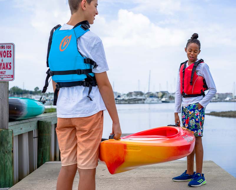 Teens carrying the Old Town Heron kayak