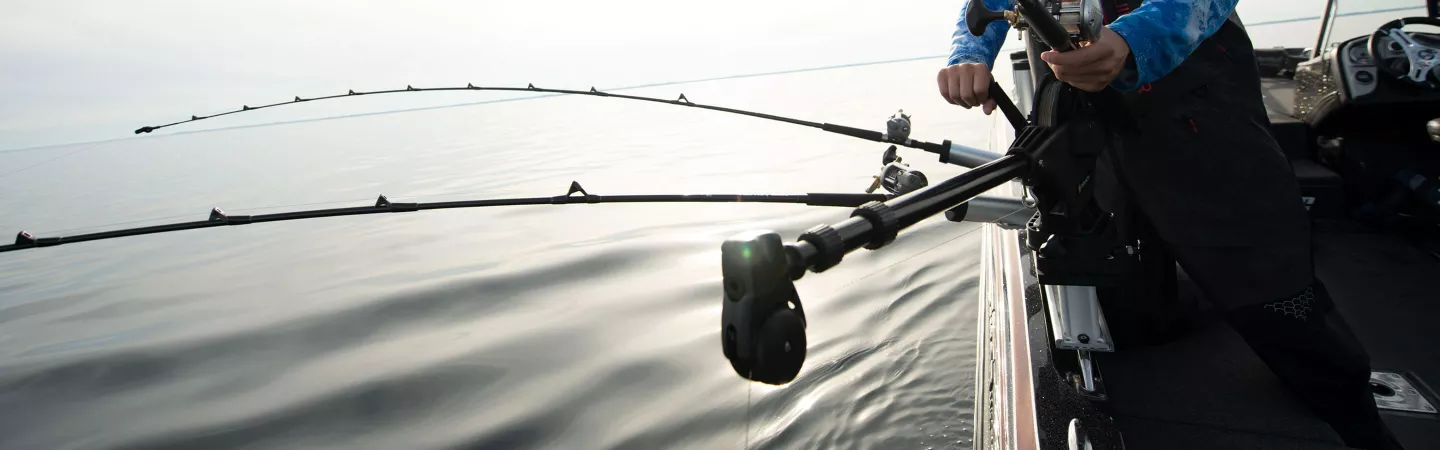 Angler setting a rod in the rod holder of the Uni-Trollmanual downrigger